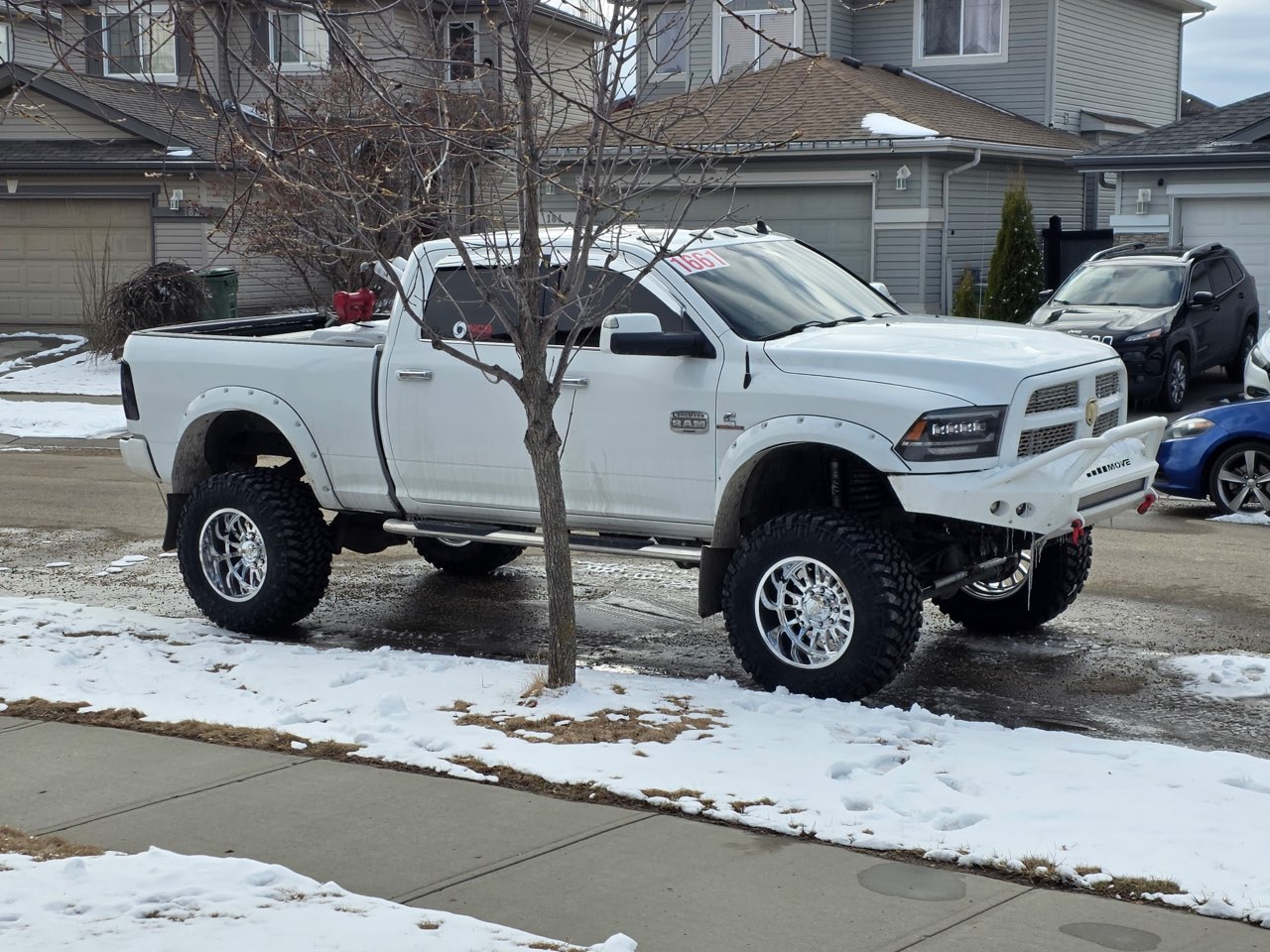 Lifted white Ram 2500 on polished forged wheels in winter