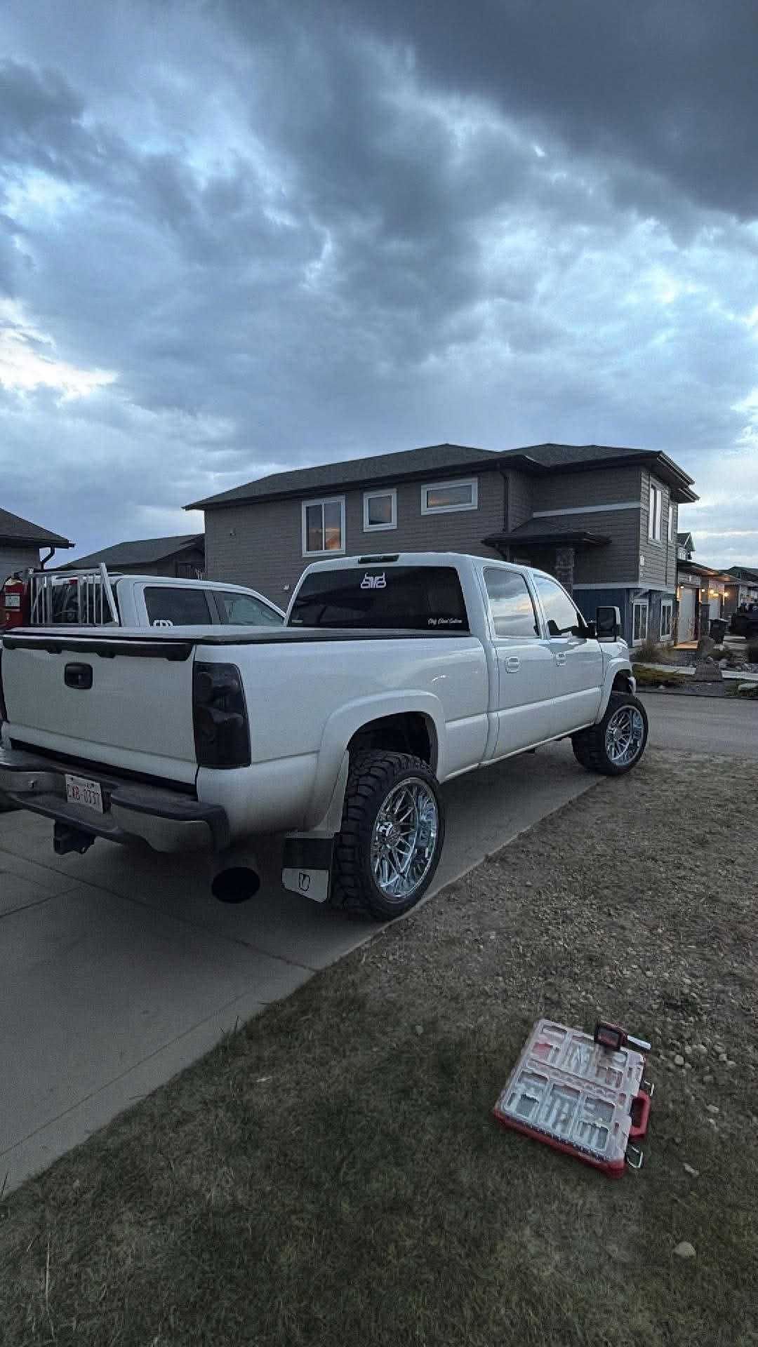 White Chevrolet Silverado 2500 lifted on chrome forged wheels